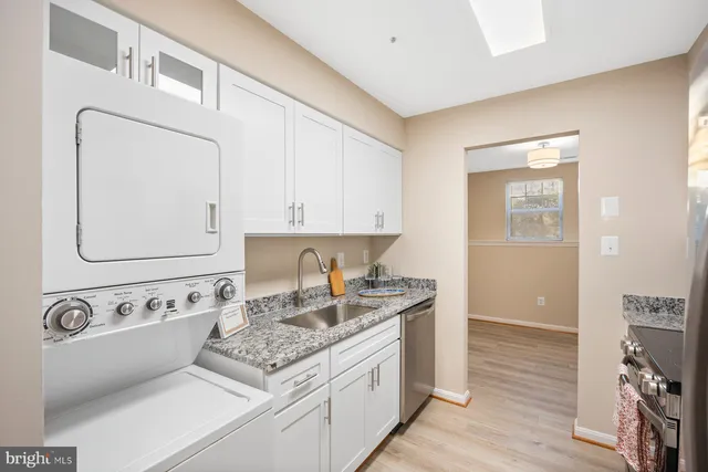 a kitchen with stainless steel appliances granite countertop a sink stove and cabinets