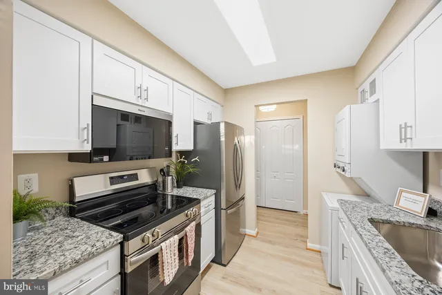 a kitchen with stainless steel appliances granite countertop a stove microwave and refrigerator