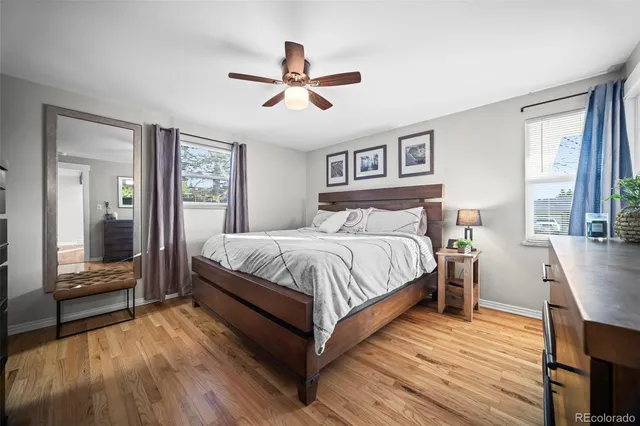 a bedroom with a large bed a chandelier and windows