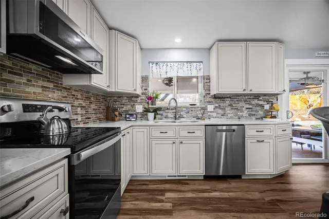 a kitchen with stainless steel appliances a sink stove and cabinets