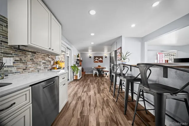 a kitchen with stainless steel appliances granite countertop refrigerator dining table and chairs