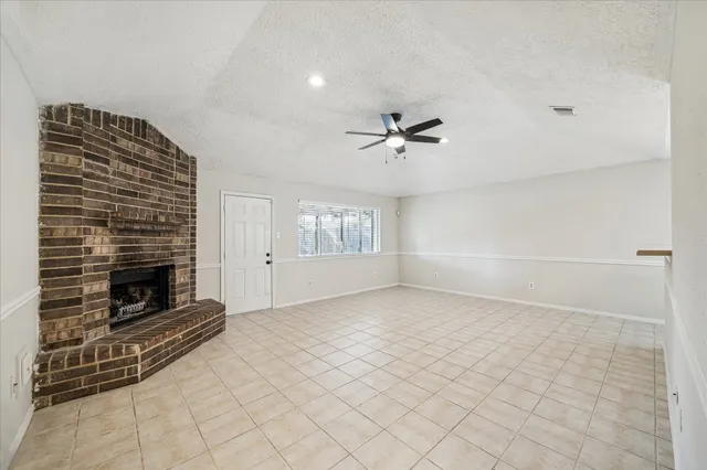 a view of an empty room with a fireplace and a window