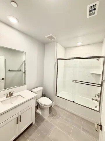 a bathroom with a granite countertop sink toilet and shower