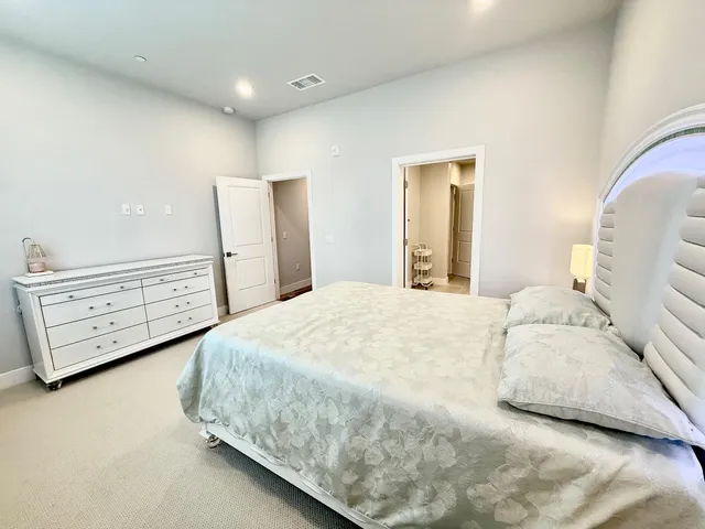 a bedroom with a bed and dresser with mirror