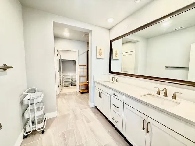 a spacious bathroom with a double vanity sink and a mirror