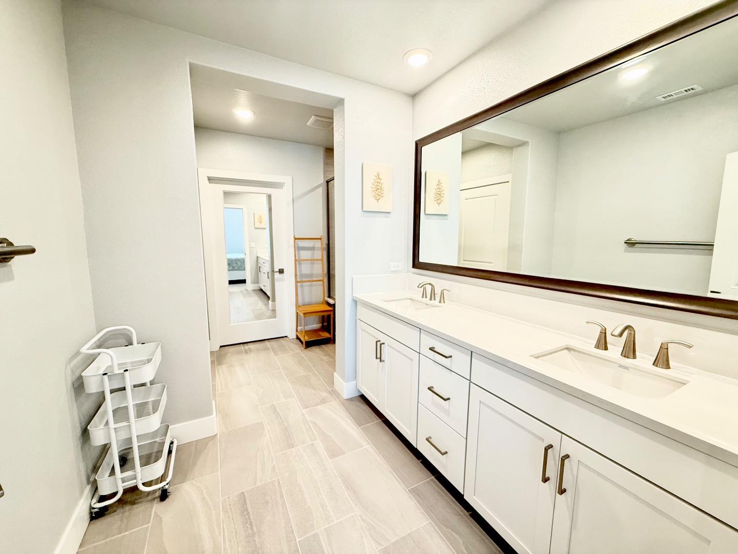 1661 Spring Street, Unit 424 Davis, CA 95616 - Photo 23 of 34 a spacious en suite bathroom with a double vanity sink a mirror and a shower