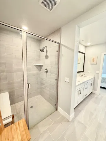 a bathroom with a double vanity sink mirror and shower
