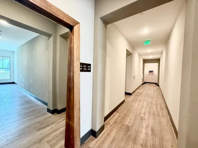a view of a hallway with wooden floor and staircase