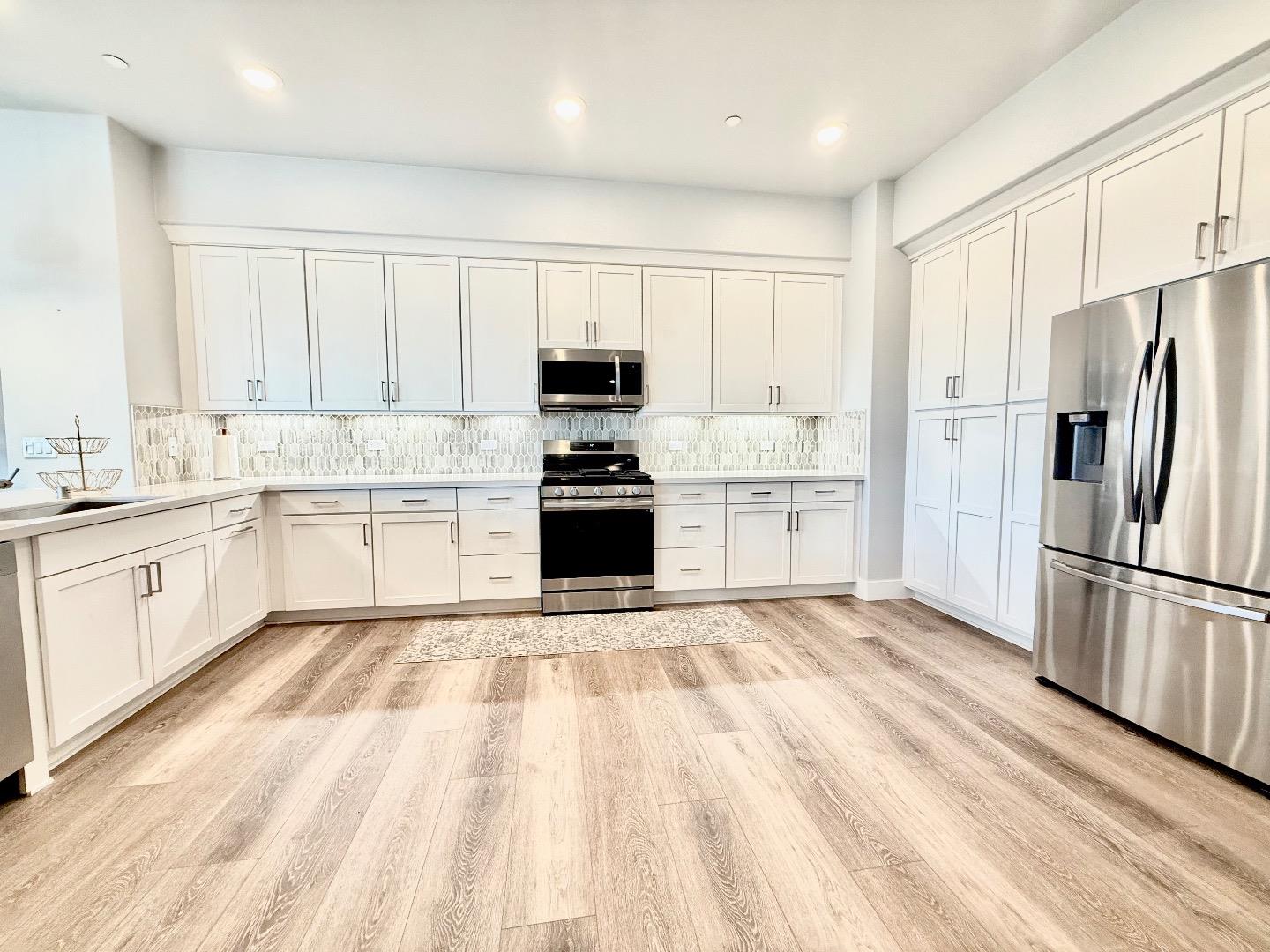 1661 Spring Street, Unit 424 Davis, CA 95616 - Photo 9 of 34 a kitchen with white cabinets and stainless steel appliances