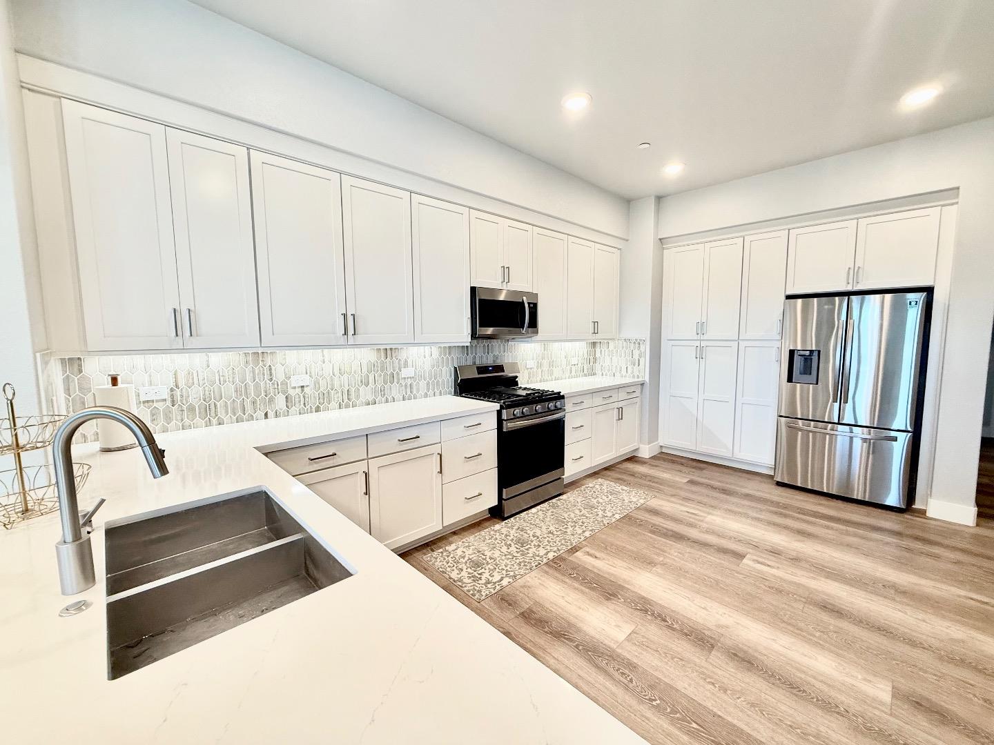 1661 Spring Street, Unit 424 Davis, CA 95616 - Photo 10 of 34 a kitchen with granite countertop a refrigerator sink and cabinets