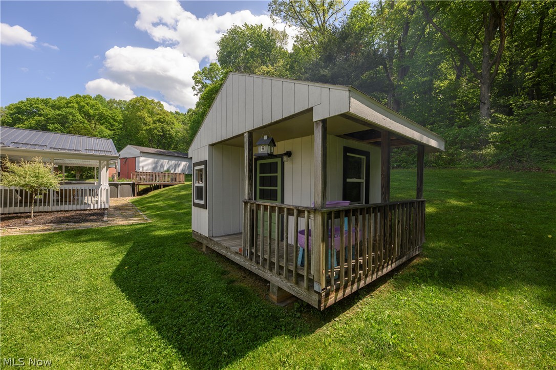 6105 Wolf Run Road Southeast Dennison, OH 44621 - Photo 7 of 35 Detached outbuilding featuring a covered porch, wood railings, and an exterior light fixture