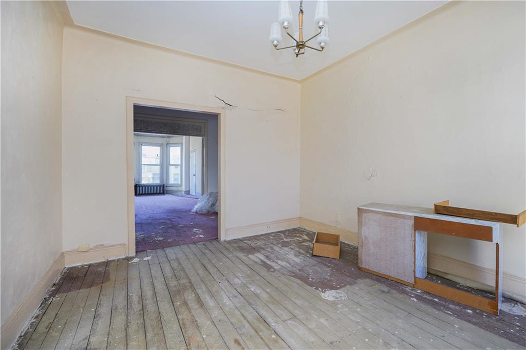 1122 39th Street Brooklyn, NY 11218 - Photo 8 of 27 a view of an empty room with wooden floor and a window