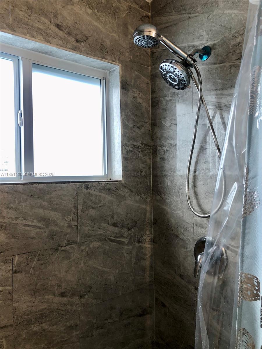 6890 Liberty Street Hollywood, FL 33024 - Photo 5 of 12 a bathroom with a window and a shower
