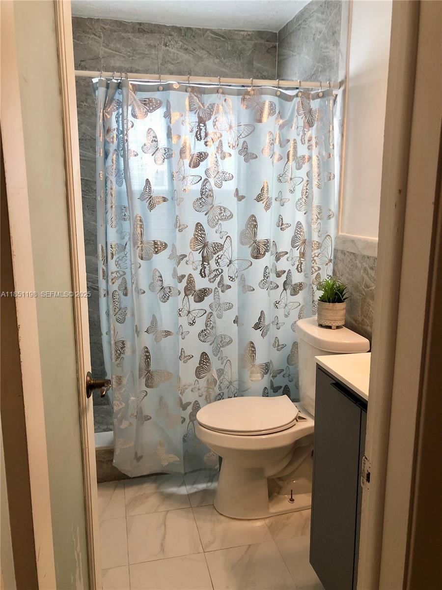 6890 Liberty Street Hollywood, FL 33024 - Photo 8 of 12 a bathroom with a toilet and a shower