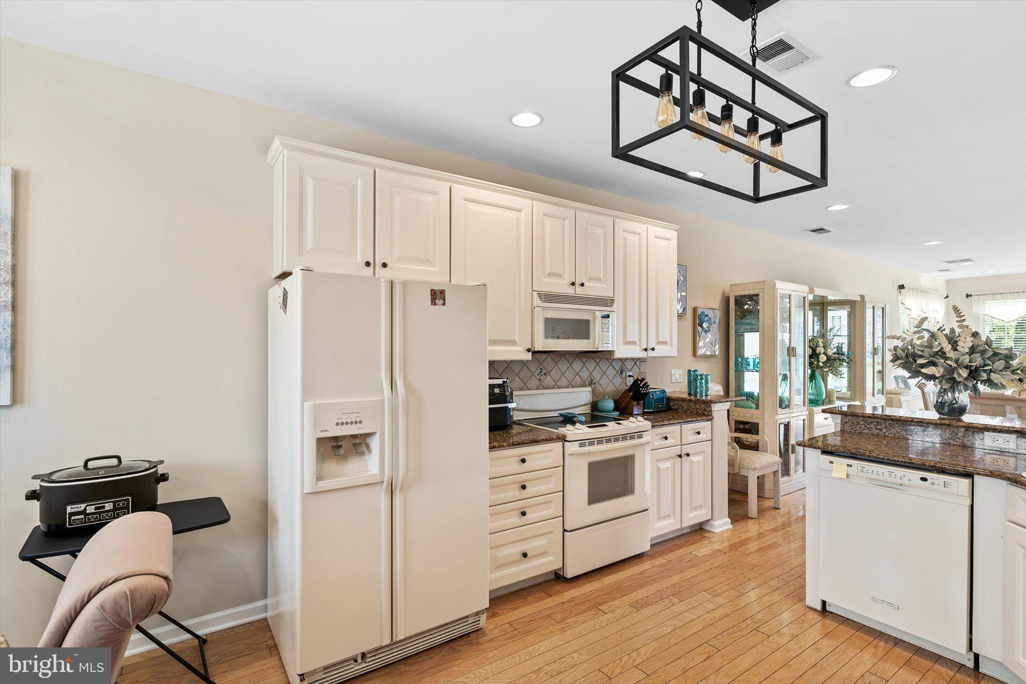 87 Chamber Lane Columbus, NJ 08022 - Photo 9 of 42 a kitchen with stainless steel appliances granite countertop a stove a sink dishwasher and white cabinets with wooden floor