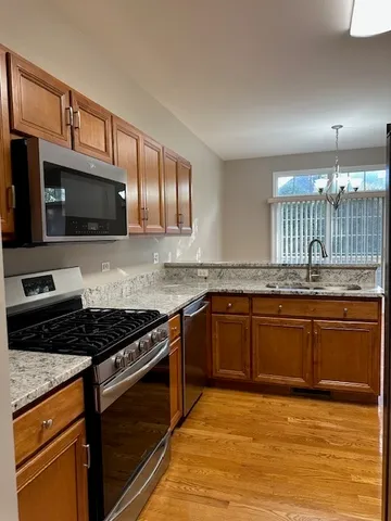 a kitchen with stainless steel appliances granite countertop a stove microwave and sink