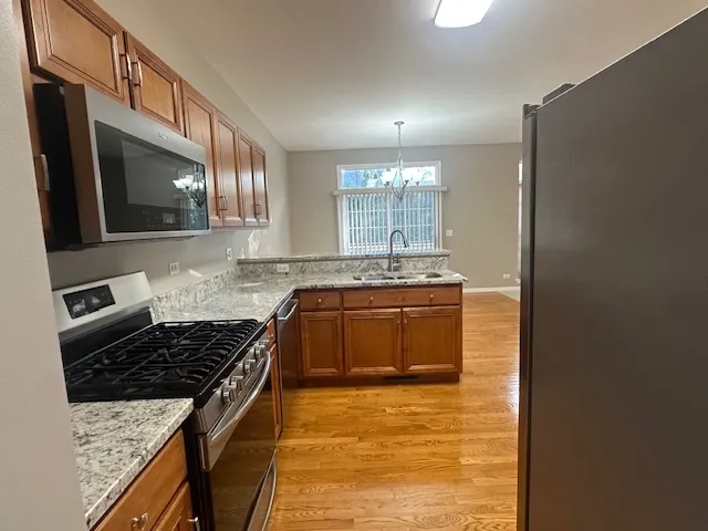 a kitchen with stainless steel appliances granite countertop a stove and a sink