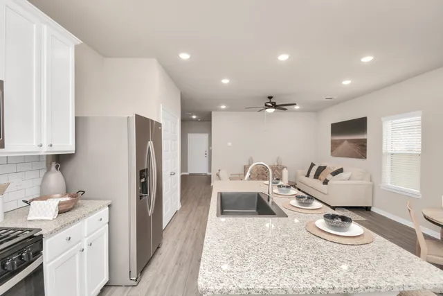 a bathroom with a granite countertop sink a mirror and shower