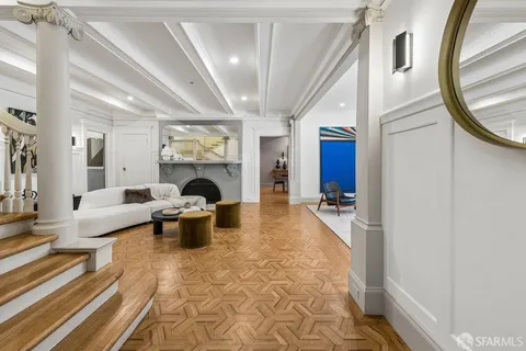 a living room with furniture a fireplace and a chandelier