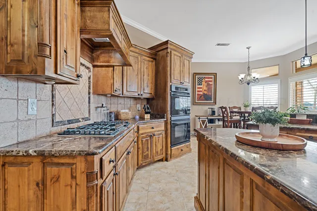 a kitchen with stainless steel appliances kitchen island granite countertop a sink and cabinets