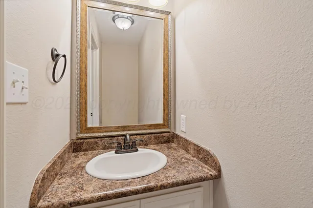 a bathroom with a granite countertop sink vanity mirror and a