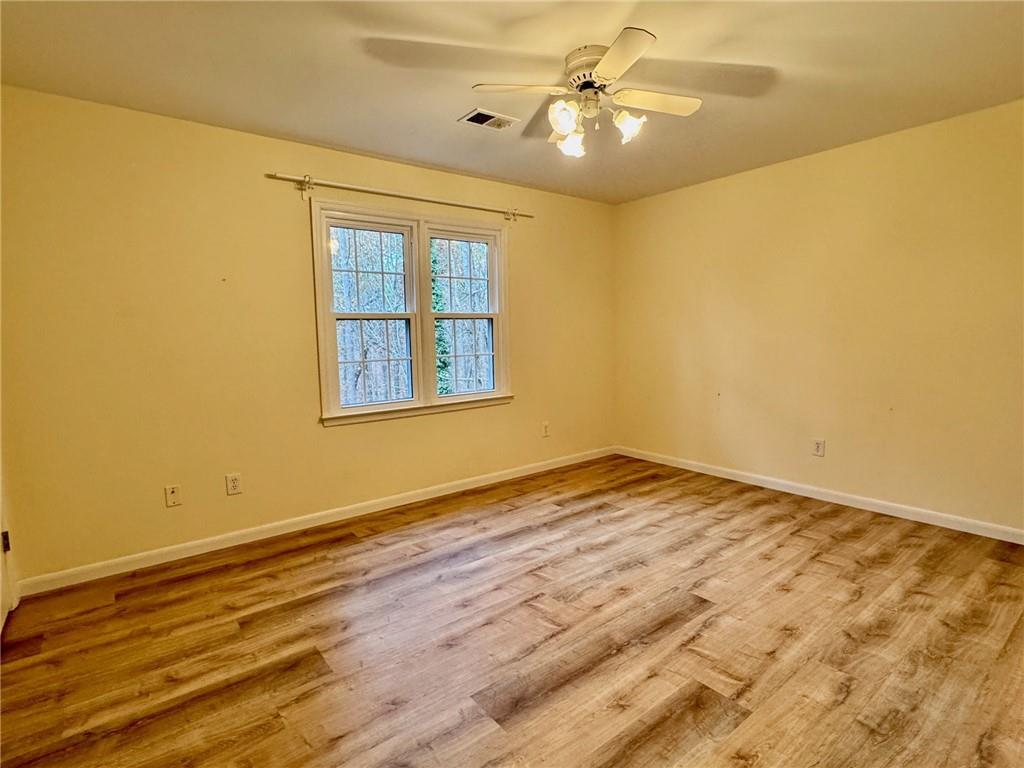 5450 Heathridge Terrace Johns Creek, GA 30097 - Photo 17 of 30 a view of empty room with wooden floor and fan