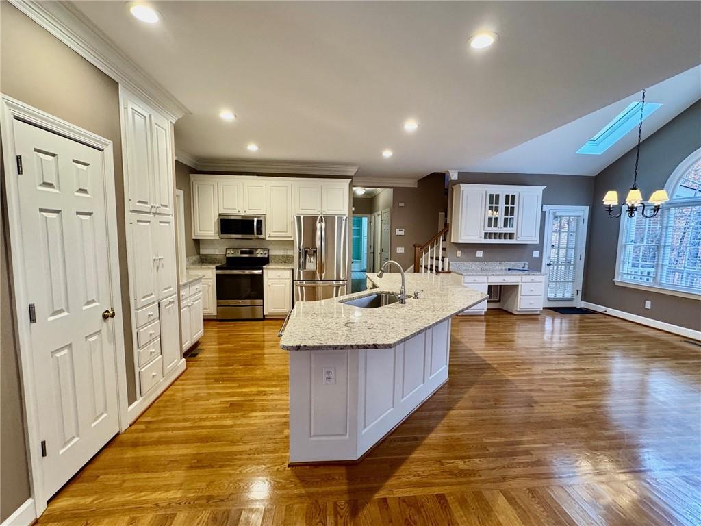 5450 Heathridge Terrace Johns Creek, GA 30097 - Photo 6 of 30 a large kitchen with stainless steel appliances kitchen island granite countertop a large kitchen island a stove a refrigerator a oven and a sink