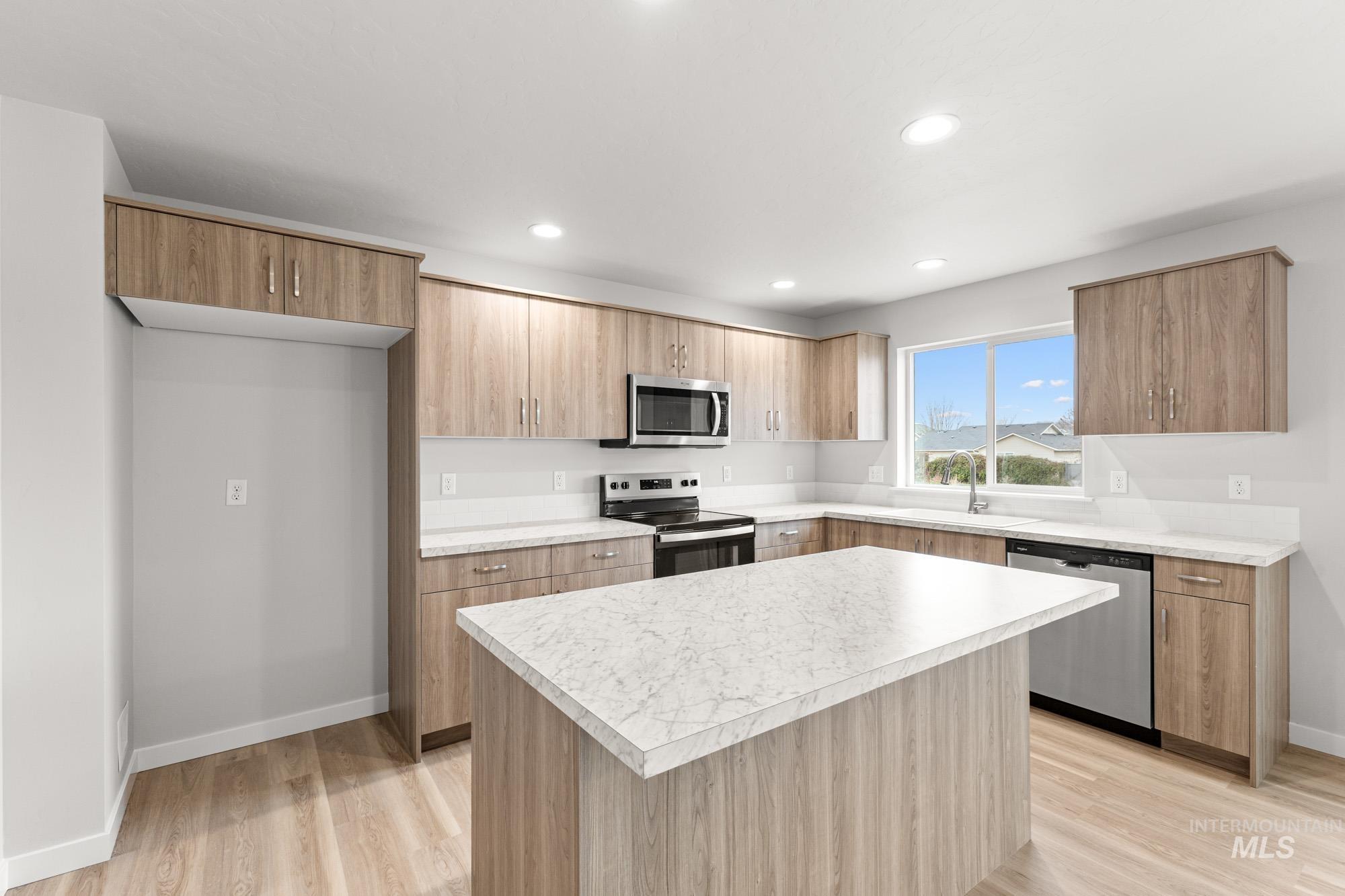 3030 South Maple Rnch Way Nampa, ID 83686 - Photo 3 of 21 Kitchen with a center island, stainless steel appliances, light wood-type flooring, light countertops, and modern cabinets