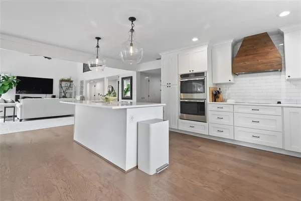 a bathroom with a granite countertop toilet a sink a mirror a window and vanity