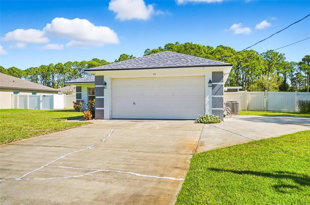 a view of a house with a yard and garage