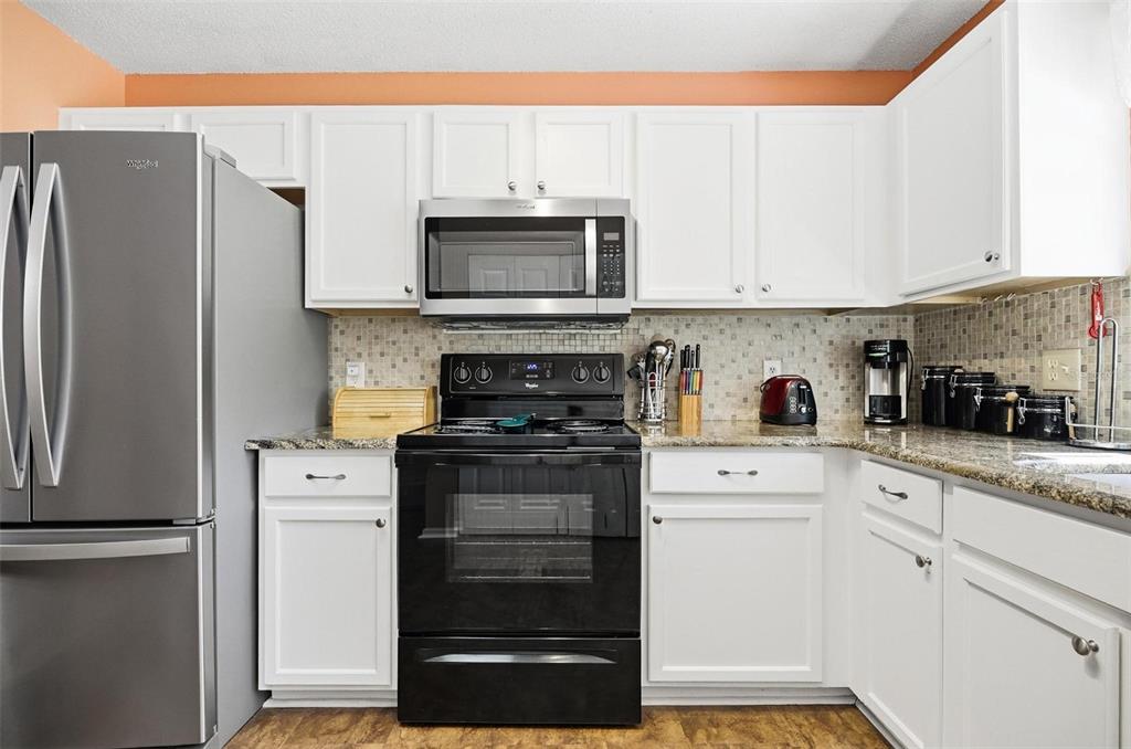 96 Ullian Trail Palm Coast, FL 32164 - Photo 11 of 42 a kitchen with stainless steel appliances white cabinets and a refrigerator