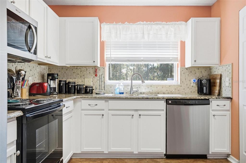 96 Ullian Trail Palm Coast, FL 32164 - Photo 12 of 42 a kitchen with stainless steel appliances granite countertop a sink and a stove