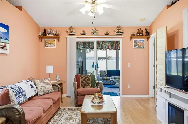 a living room with furniture a flat screen tv and a floor to ceiling window