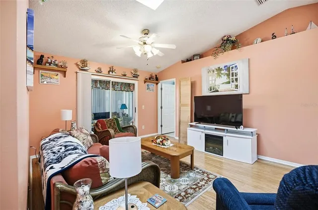 a living room with furniture a flat screen tv and kitchen view