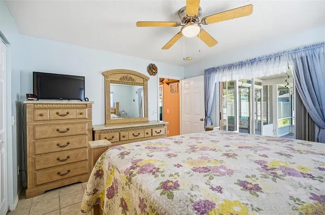 a bedroom with a bed a flat tv screen and a dresser