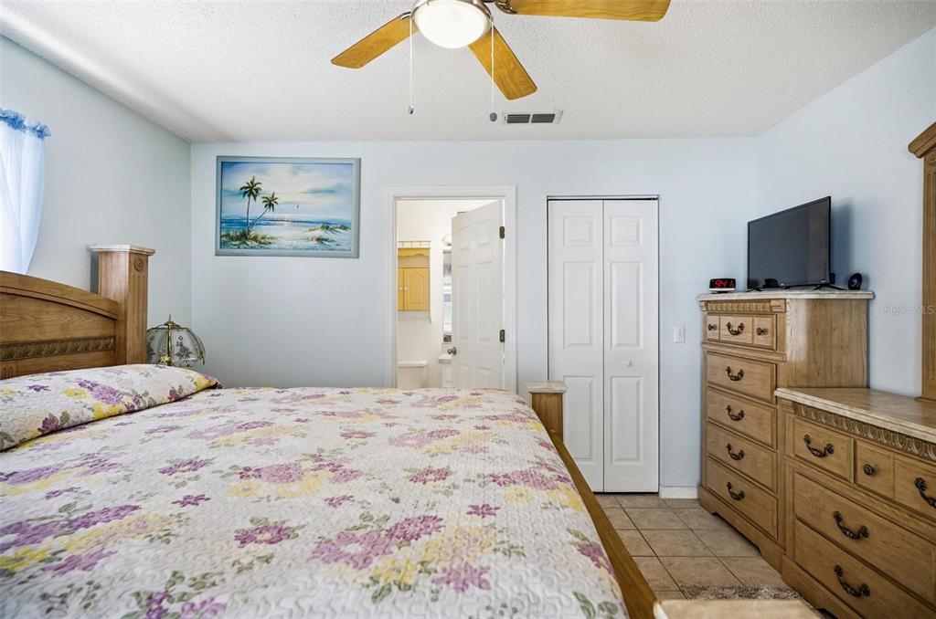 96 Ullian Trail Palm Coast, FL 32164 - Photo 19 of 42 a bedroom with a bed and a flat tv screen on dresser