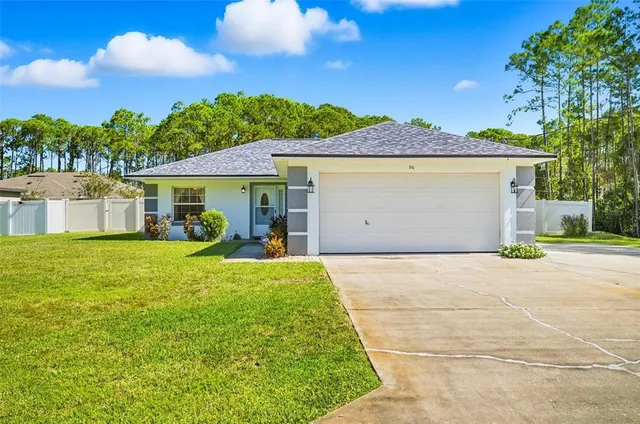 a front view of a house with a garden and yard