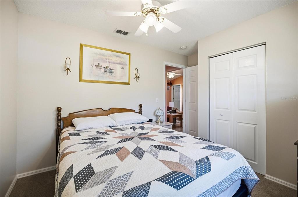 96 Ullian Trail Palm Coast, FL 32164 - Photo 29 of 42 a bedroom with a white bed and a chandelier