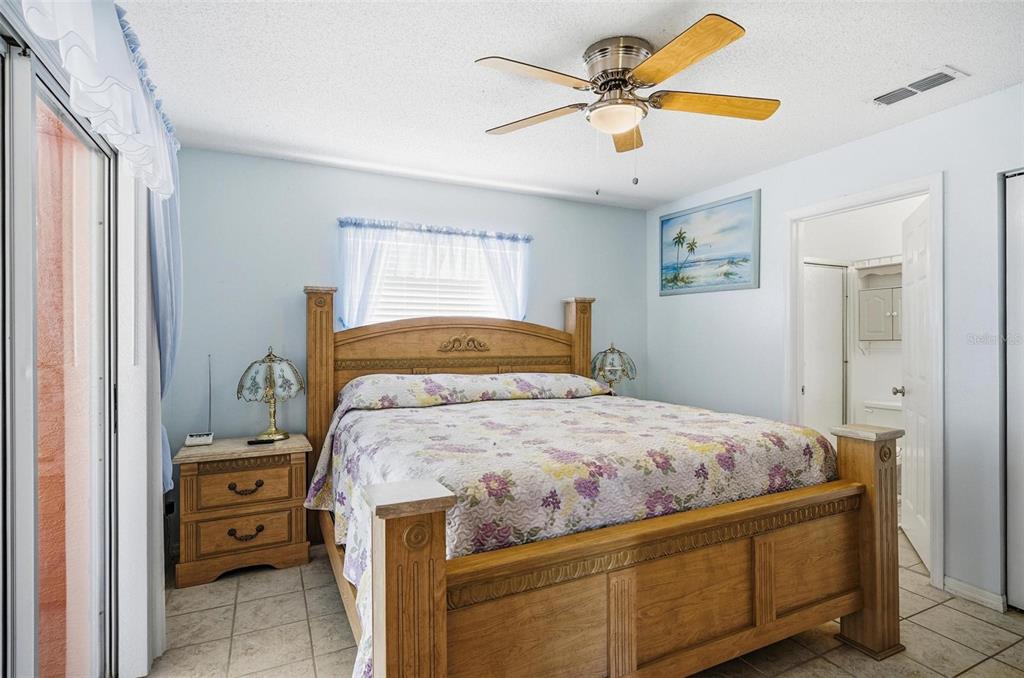 96 Ullian Trail Palm Coast, FL 32164 - Photo 30 of 42 a bedroom with a bed and a chandelier
