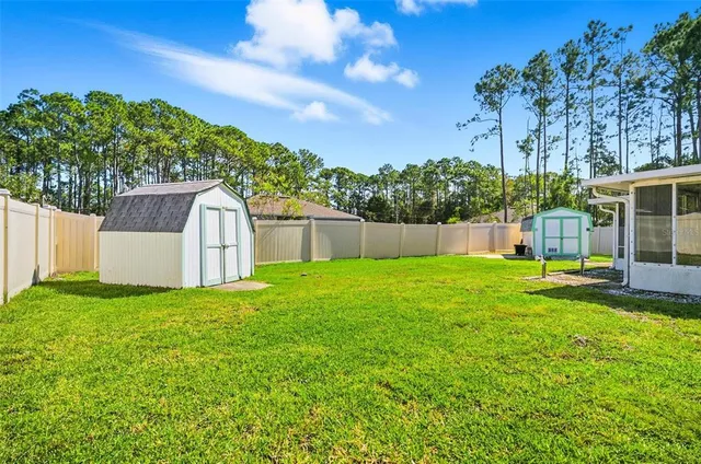 a view of a house with backyard and tree