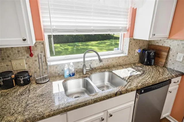 a kitchen with a granite countertop sink and window