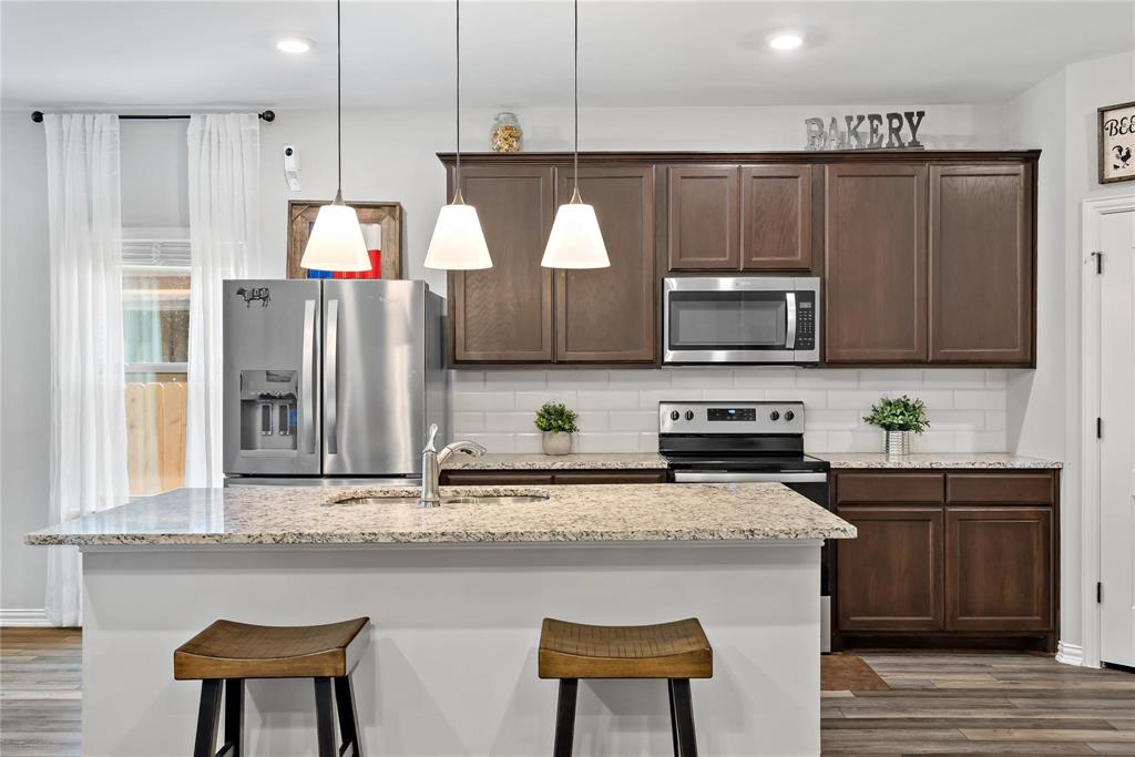 2003 Atlantic Avenue Anna, TX 75409 - Photo 10 of 22 a kitchen with stainless steel appliances granite countertop a stove a sink and a microwave