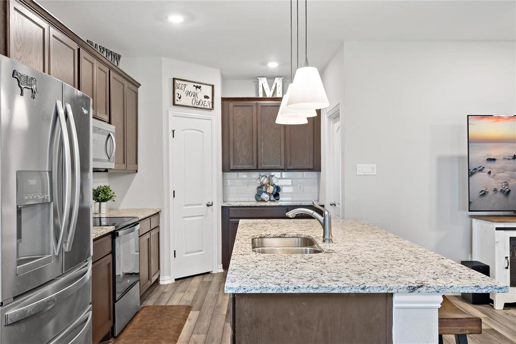 2003 Atlantic Avenue Anna, TX 75409 - Photo 11 of 22 a kitchen with stainless steel appliances granite countertop a sink refrigerator and microwave