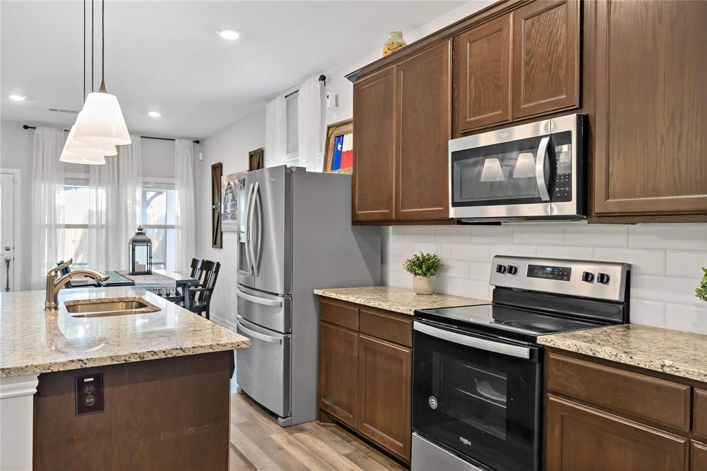 2003 Atlantic Avenue Anna, TX 75409 - Photo 12 of 22 a kitchen with stainless steel appliances granite countertop a refrigerator a stove a sink and a microwave