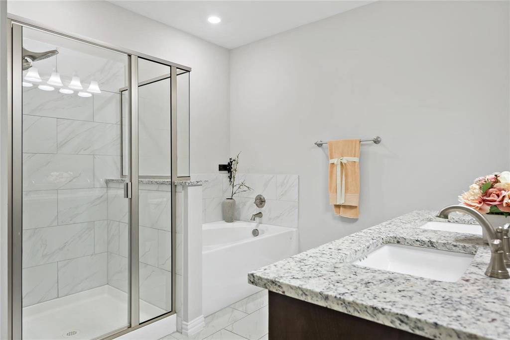 2003 Atlantic Avenue Anna, TX 75409 - Photo 16 of 22 a bathroom with a granite countertop sink a shower and a mirror