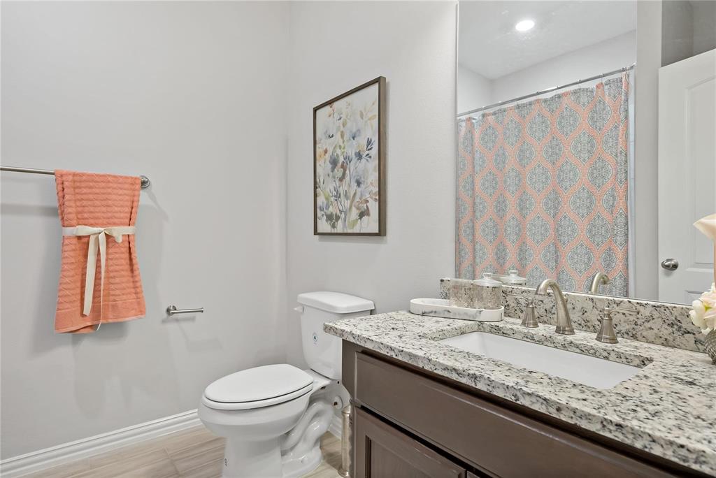2003 Atlantic Avenue Anna, TX 75409 - Photo 6 of 22 a bathroom with a granite countertop sink a toilet and a mirror