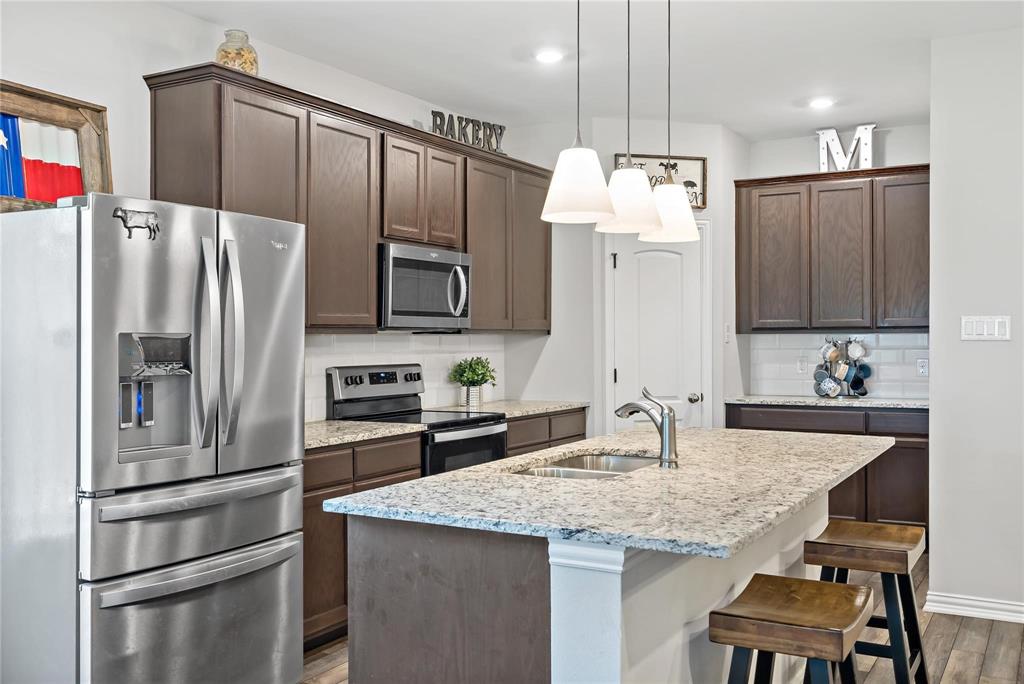 2003 Atlantic Avenue Anna, TX 75409 - Photo 9 of 22 a kitchen with granite countertop a refrigerator and microwave