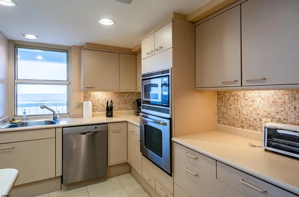 a kitchen with stainless steel appliances granite countertop a sink a stove and a refrigerator