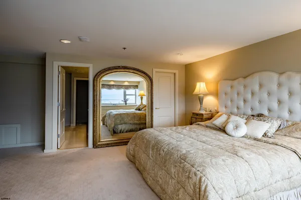 a bedroom with a large bed and a large mirror