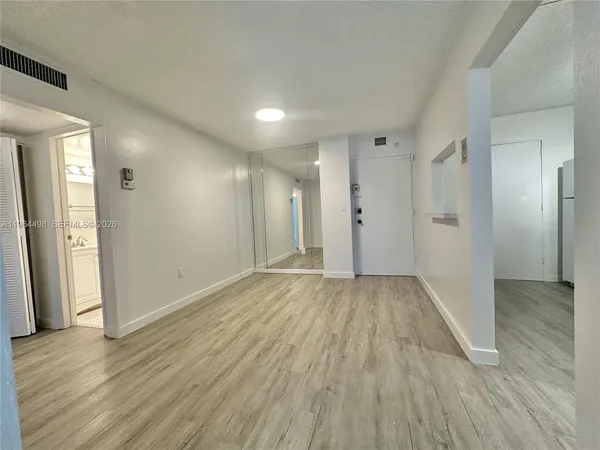 a view of an empty room with wooden floor